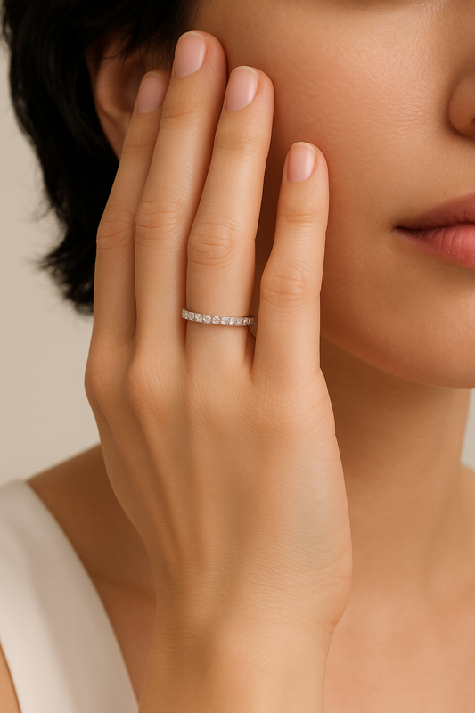Close-up of a hand wearing a silver ring with a blurred background