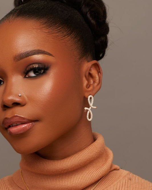 Woman wearing a brown ribbed sweater against a plain background