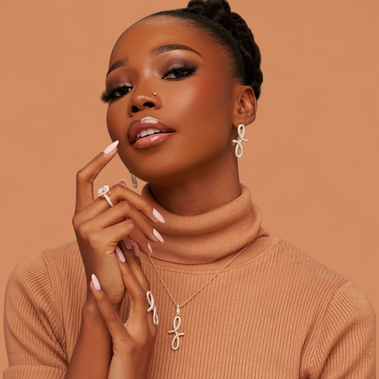 Woman wearing a brown turtleneck sweater with jewelry on a brown background
