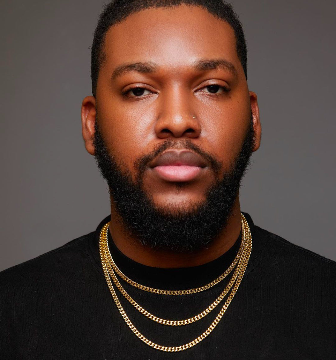 A man wearing a gold-colored chain necklace.