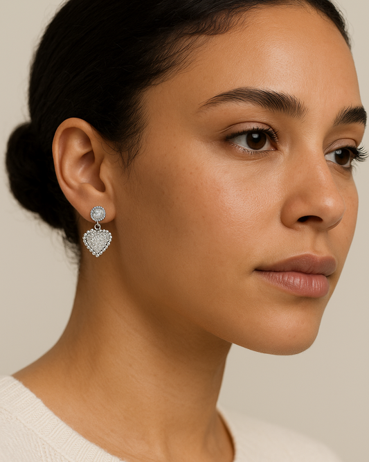 Close-up of a woman wearing heart-shaped earrings with a neutral background