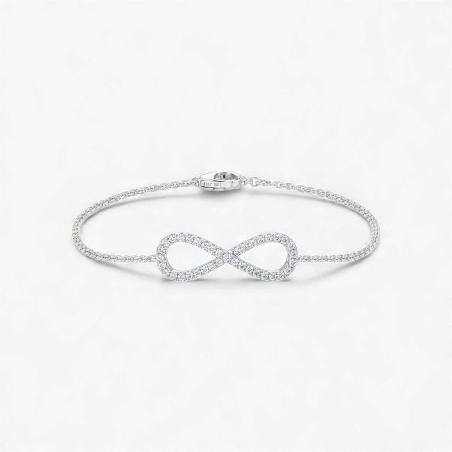 Silver infinity bracelet on a light gray background