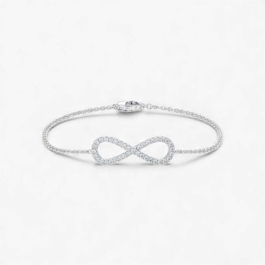 Silver infinity bracelet on a light gray background