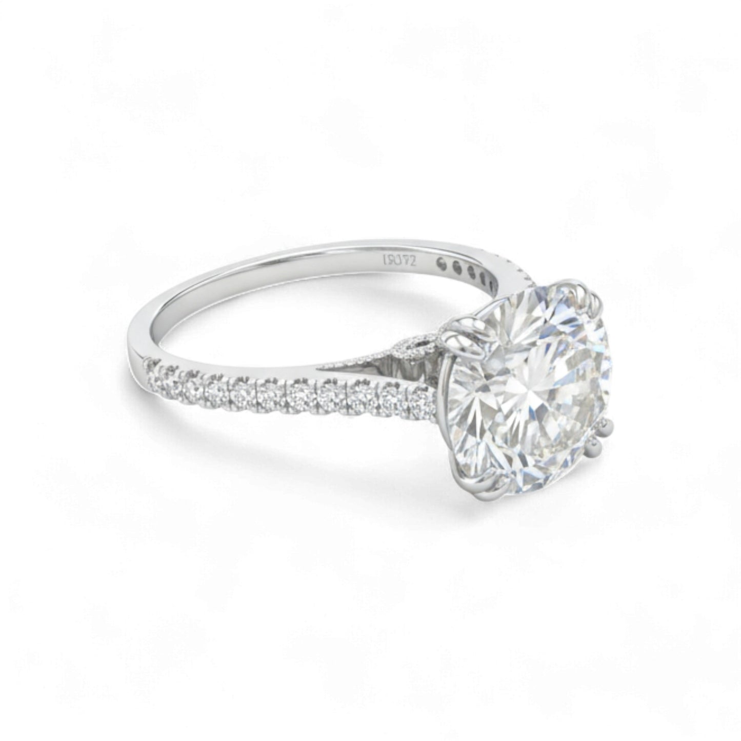 Diamond ring with a large central gemstone and smaller stones on the band against a white background