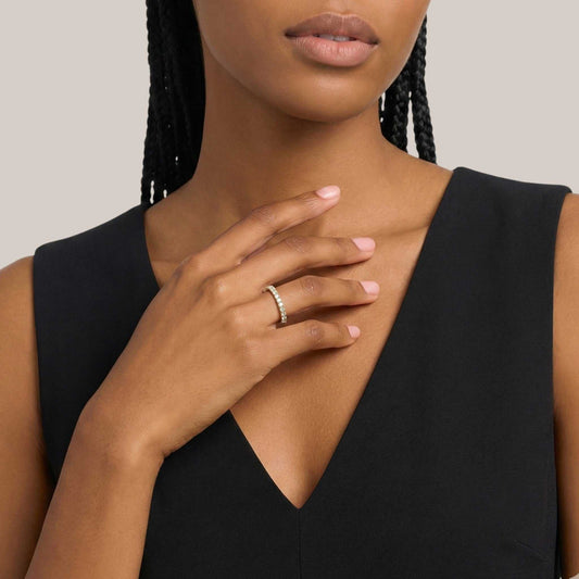 Woman wearing a black sleeveless top with a neutral background