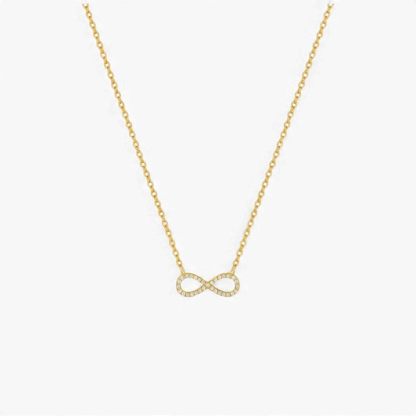 Gold infinity necklace on a white background