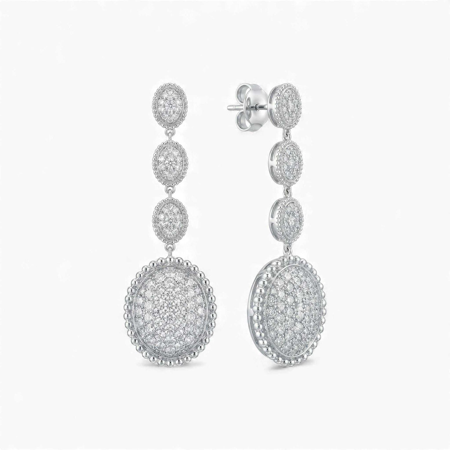 Pair of silver earrings with circular designs on a white background