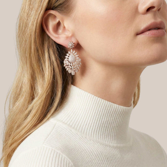 Close-up of a woman wearing a pair of earrings with a neutral background