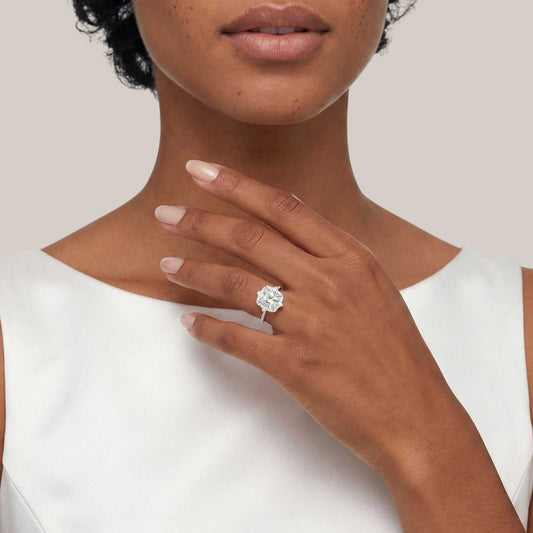 Woman wearing a diamond ring on a plain background