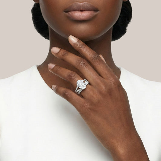 Close-up of a hand wearing a diamond ring with a plain background