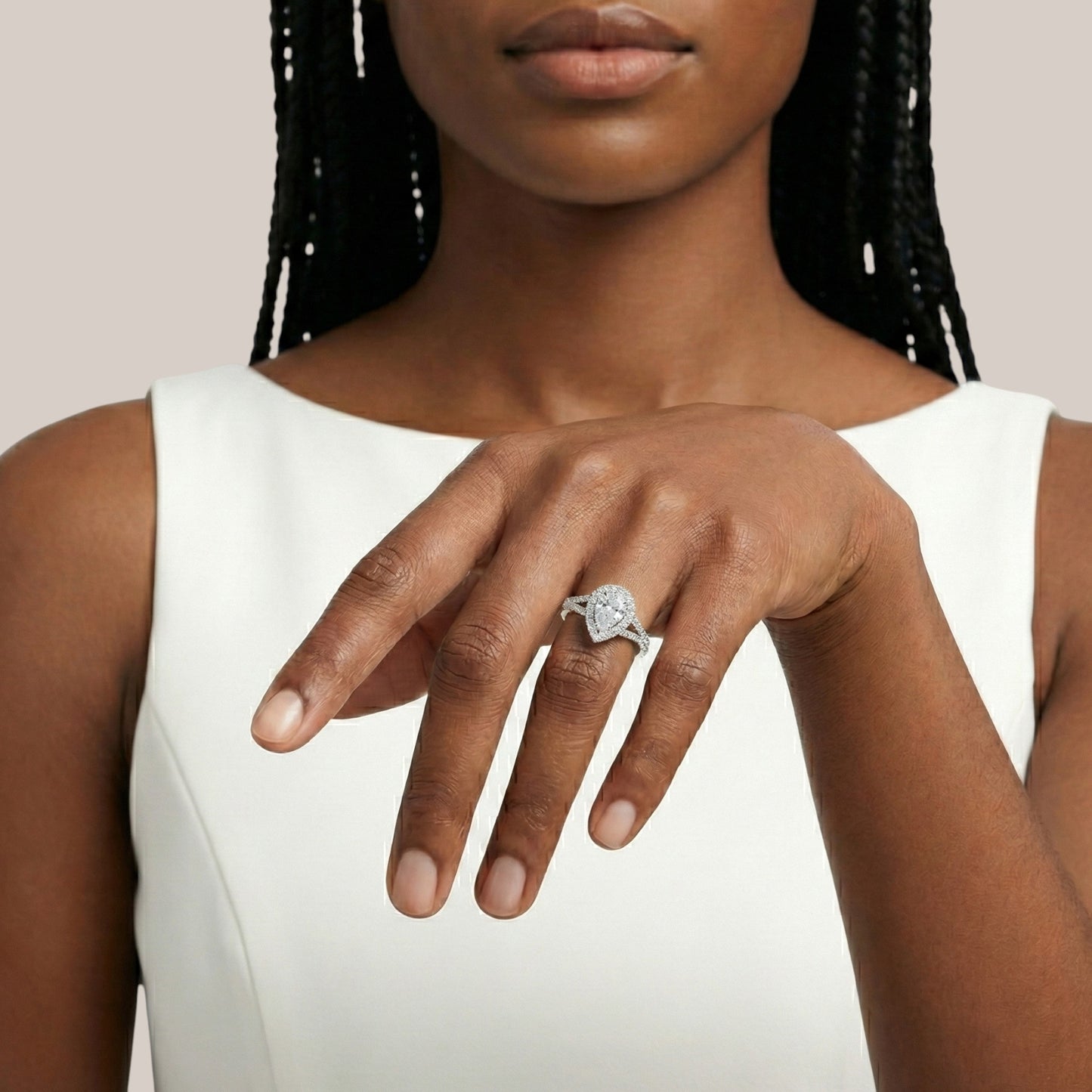 Woman wearing a diamond ring on her hand against a neutral background