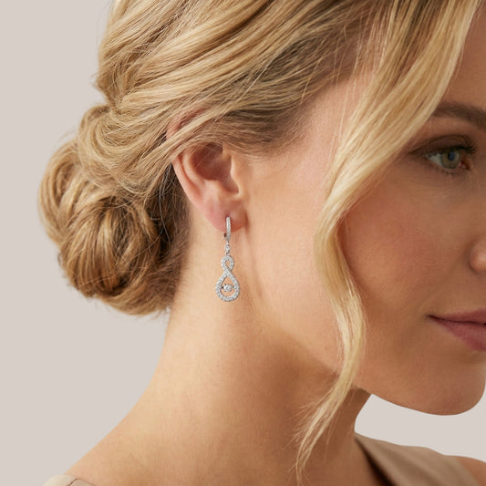 Close-up of a woman wearing a diamond earring with a neutral background