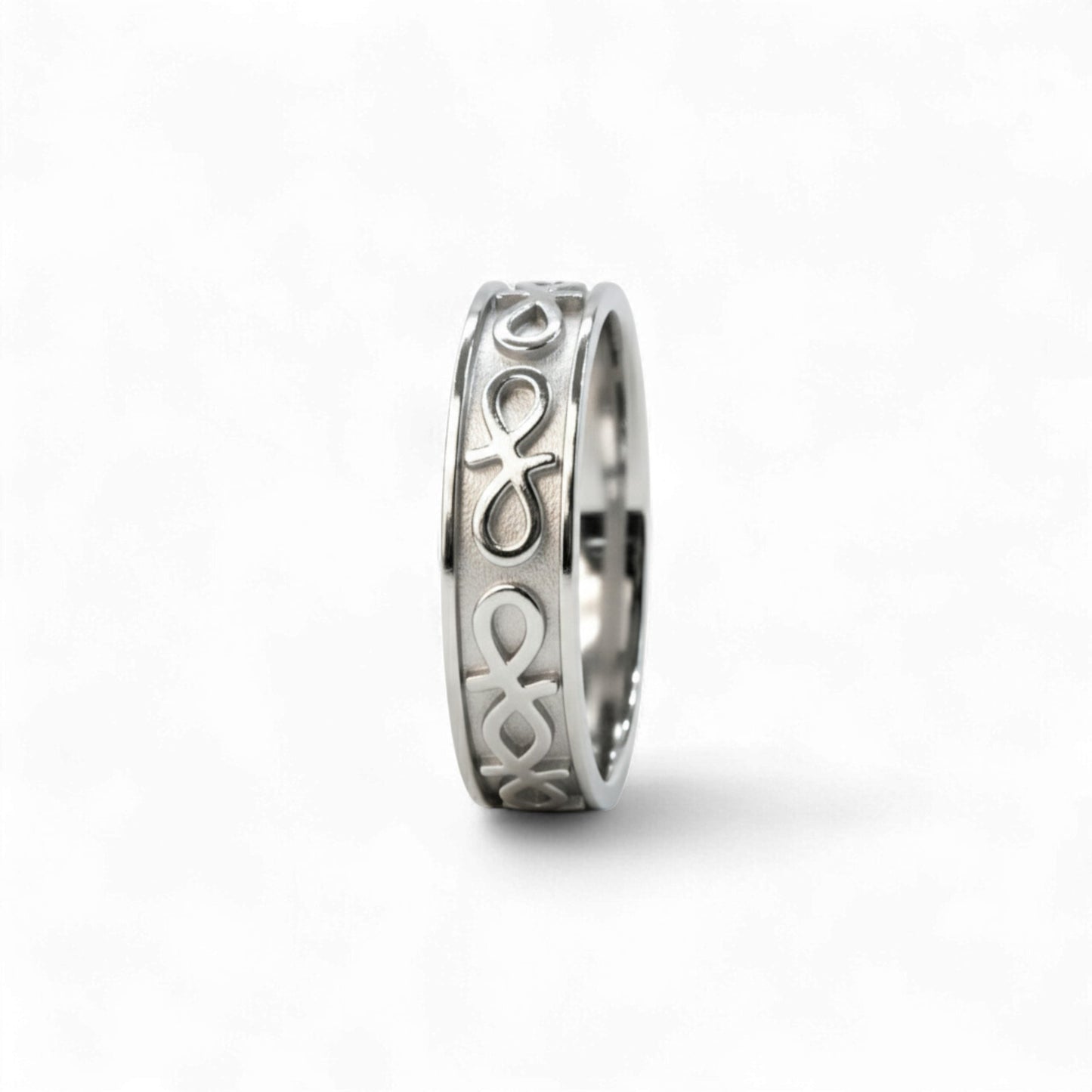 Silver ring with intricate design on a white background