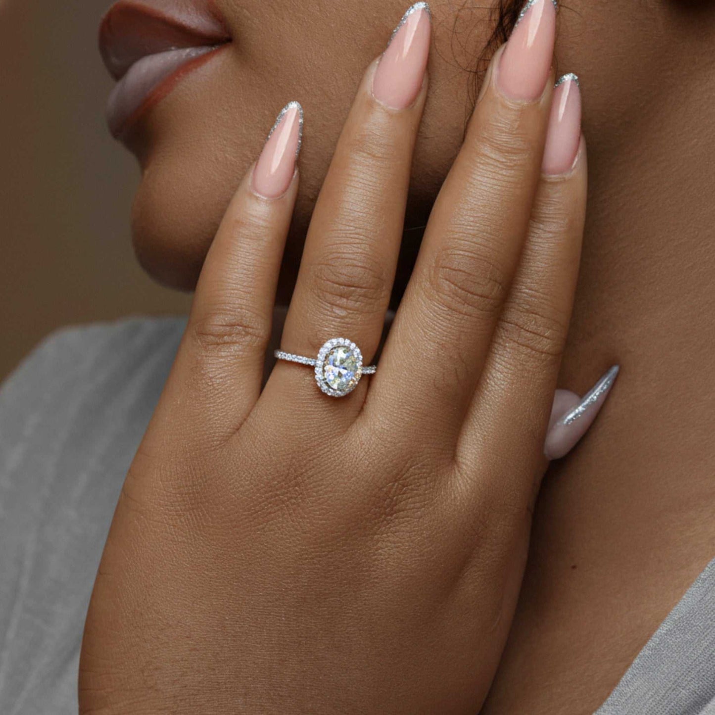 Classic Halo Oval Cut CZ engagement ring in 925 sterling silver worn on hand with oval cubic zirconia center stone and halo setting