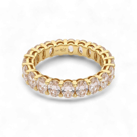 Gold ring with clear gemstones on a white background