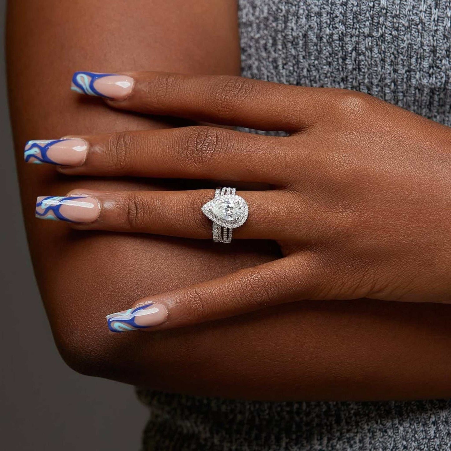 Lovely Pear Cut CZ bridal set in 925 sterling silver with pear-cut cubic zirconia center and pavé halo on hand