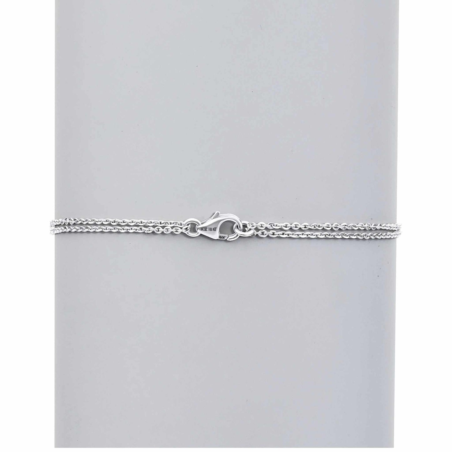 Silver chain bracelet on a light gray background