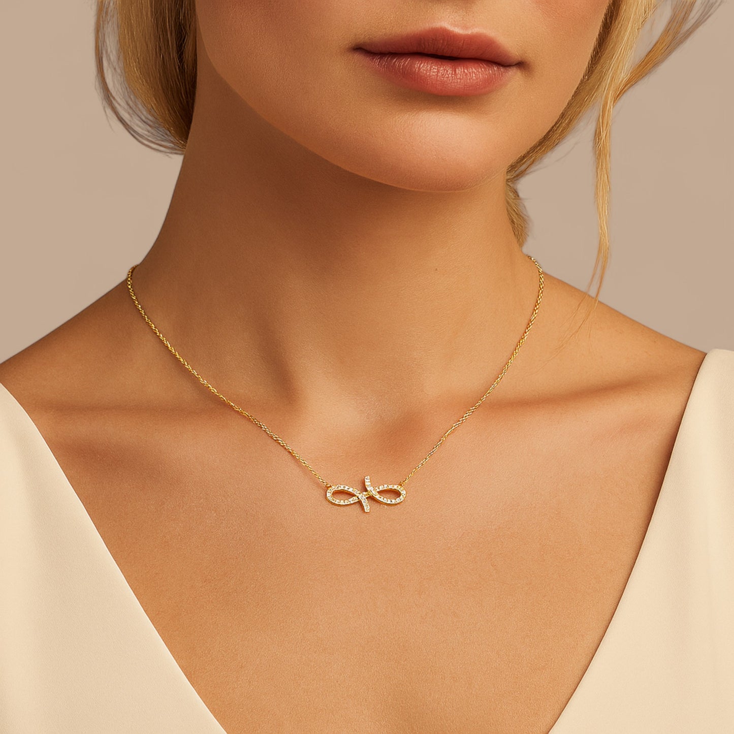 Gold necklace with a delicate pendant worn by a model against a neutral background