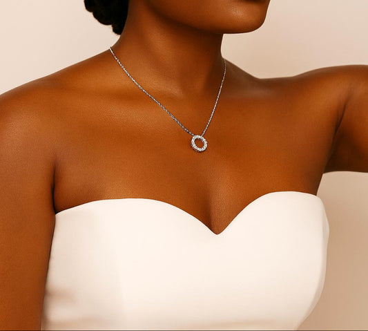 Woman wearing a white strapless dress with jewelry on a beige background
