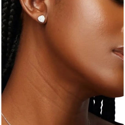 Close-up of a person wearing heart-shaped earrings with a blurred background