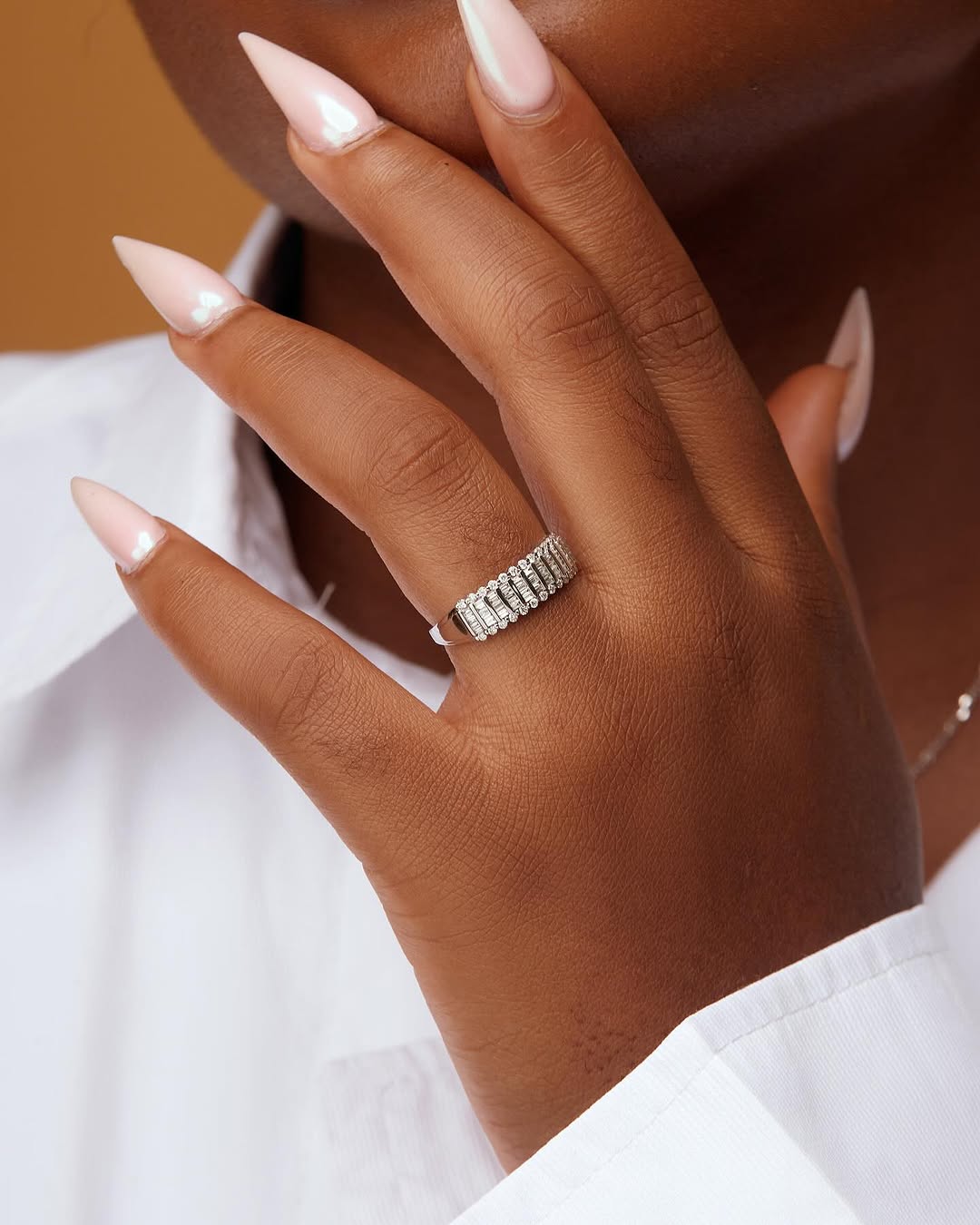 A person wearing a gold band ring on their finger.