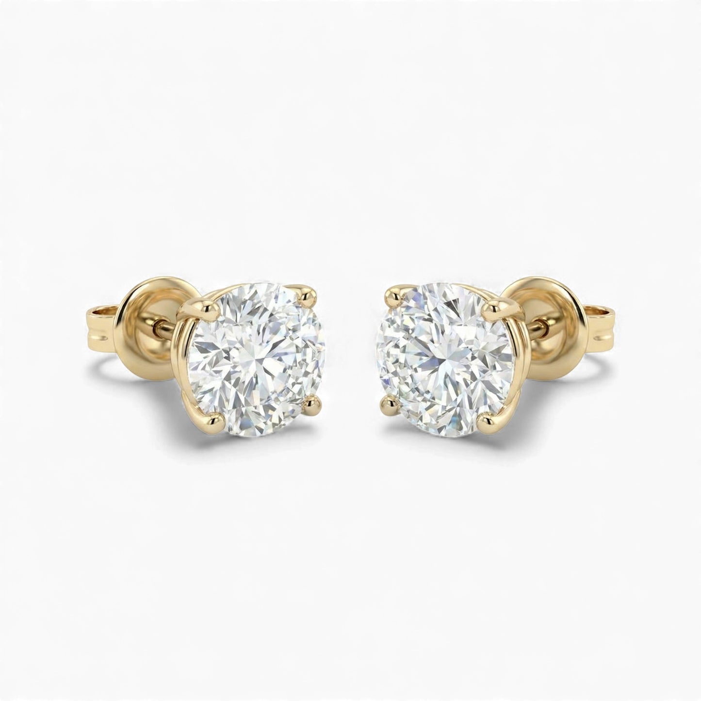 Gold stud earrings with clear gemstones on a white background