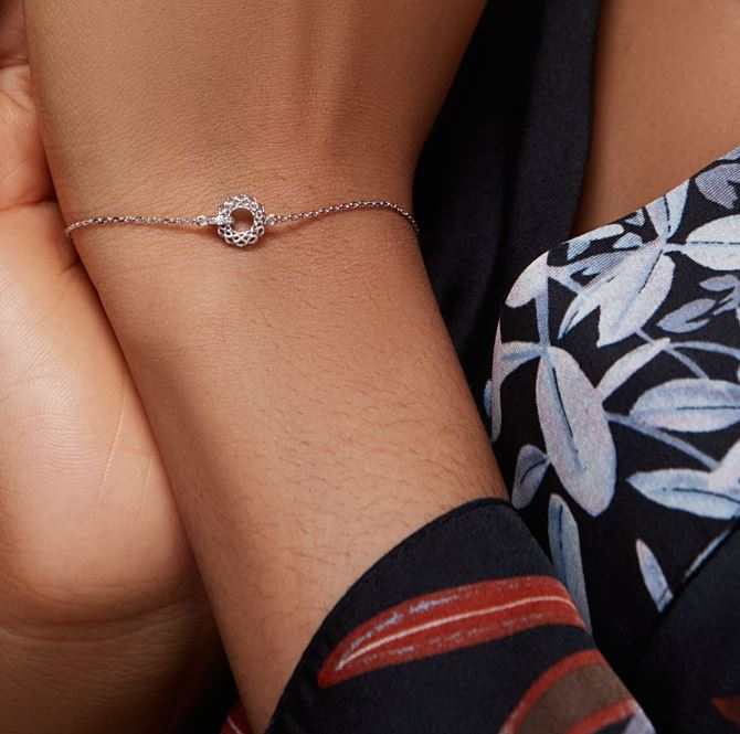 Close-up of wrist wearing a delicate Laser Ball Diamond Bracelet in 18K gold with laser-cut gold beads and a solitaire diamond
