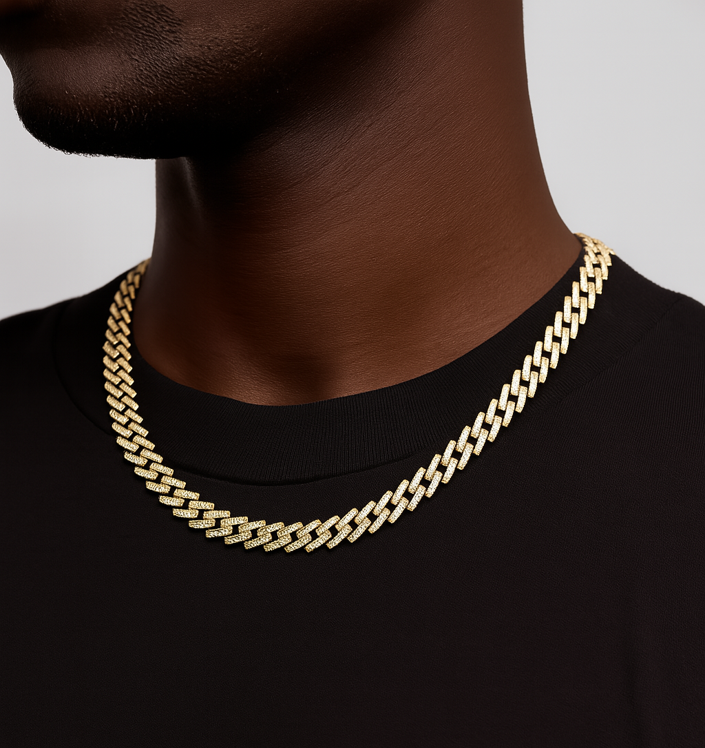 Gold chain necklace on a person wearing a black shirt against a gray background