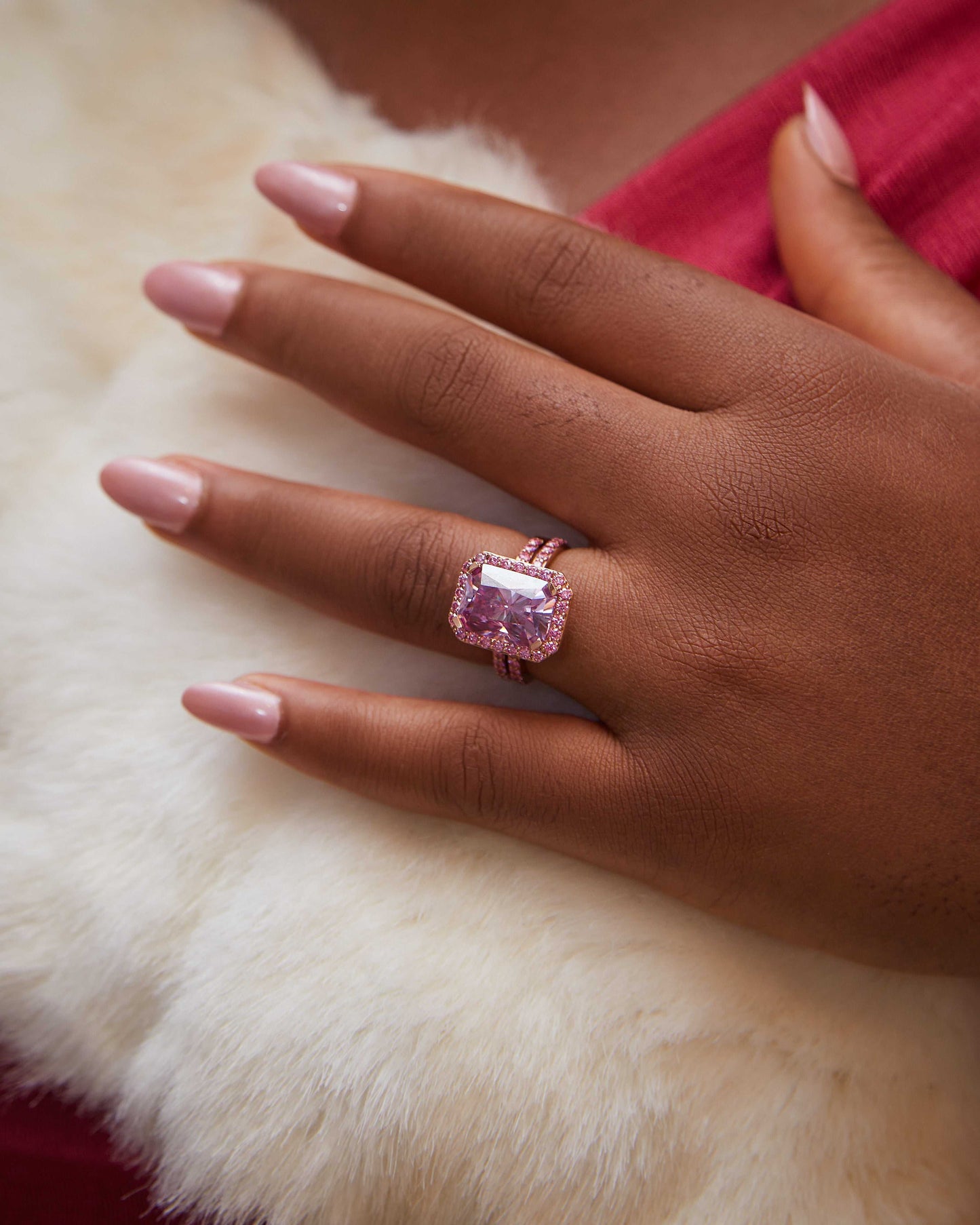 Jamila Pink Moissanite bridal ring set in 18K gold on hand with pink nails