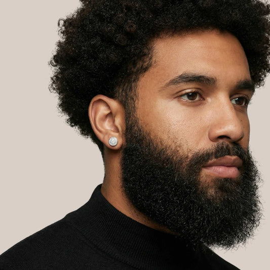 Man with a beard wearing a black turtleneck against a neutral background