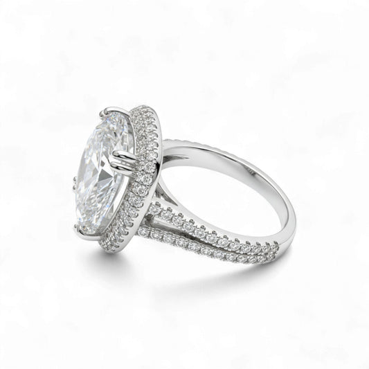 Silver ring with a large central gemstone and smaller stones on the band against a white background