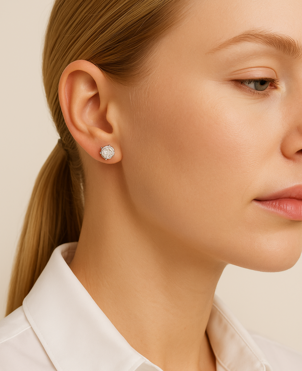 Close-up of a woman wearing diamond earrings with a neutral background