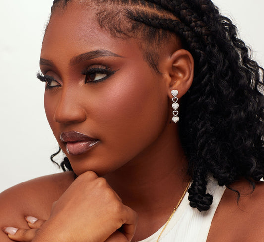 Woman wearing gold jewelry against a neutral background