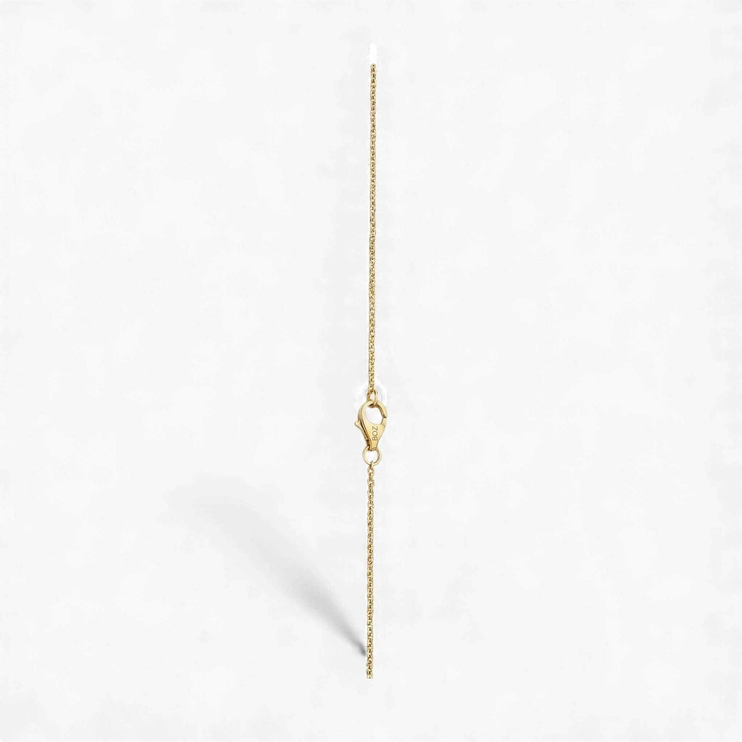 Gold chain necklace on a light gray background