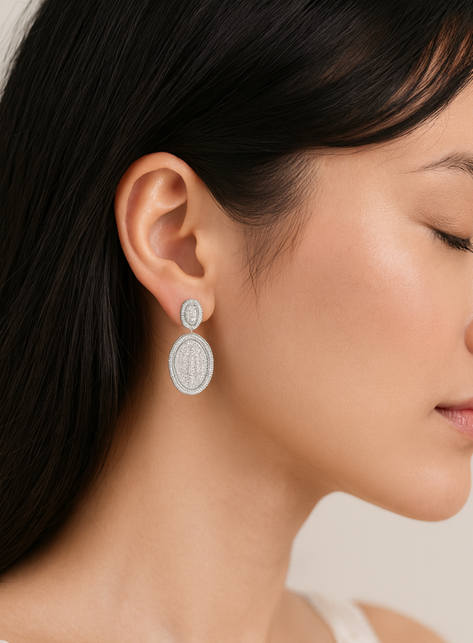 Close-up of a woman wearing silver earrings with a neutral background, featuring the BOZ Jewelry brand.