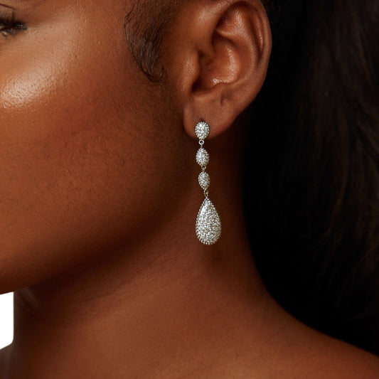 Close-up of a woman wearing a silver teardrop earring.