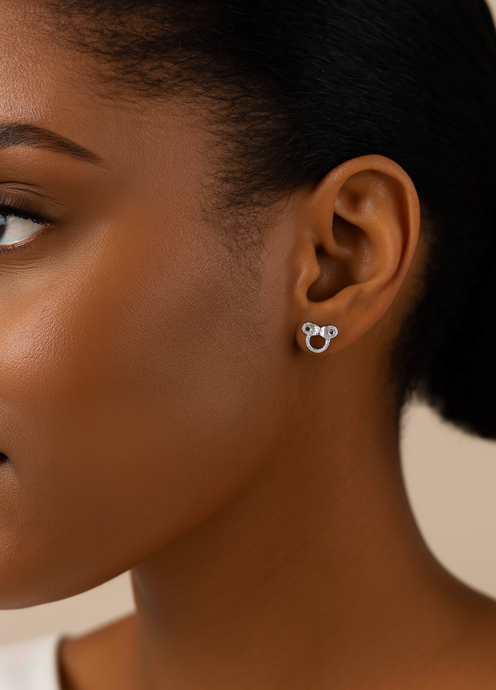 Close-up of a person wearing silver hoop earrings with a neutral background