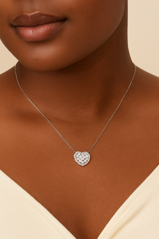 Necklace with a heart-shaped pendant worn by a person against a neutral background