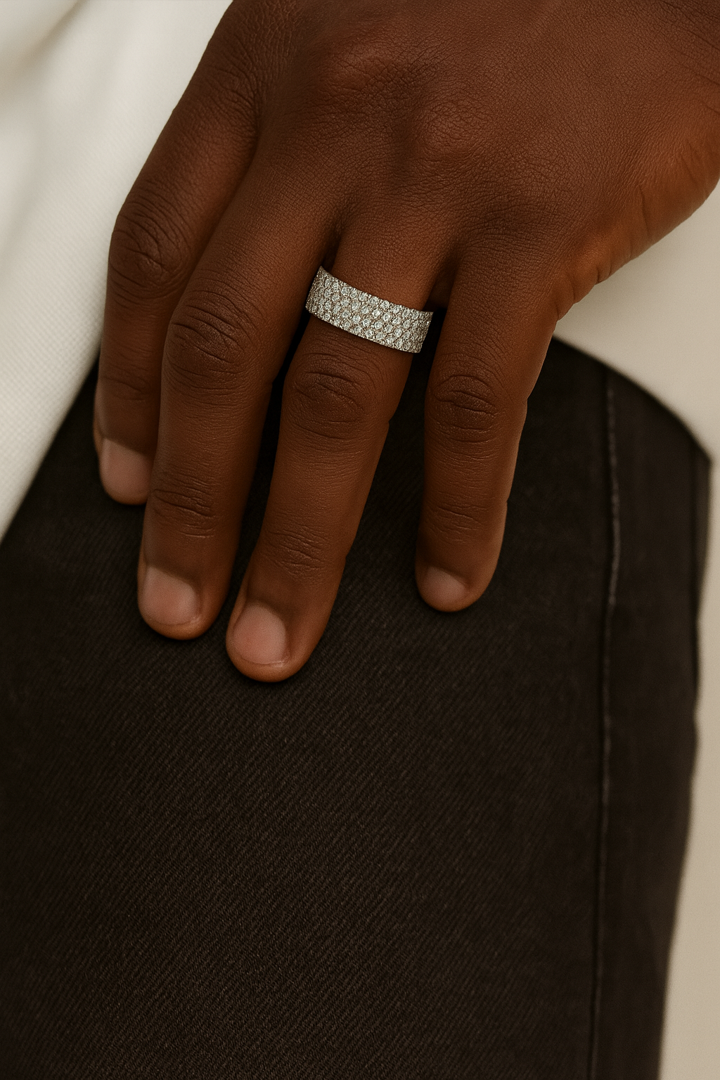 Hand wearing a silver ring on a dark surface