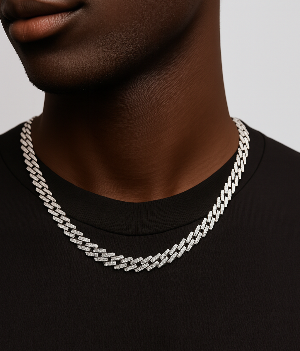 Person wearing a silver chain necklace on a plain background