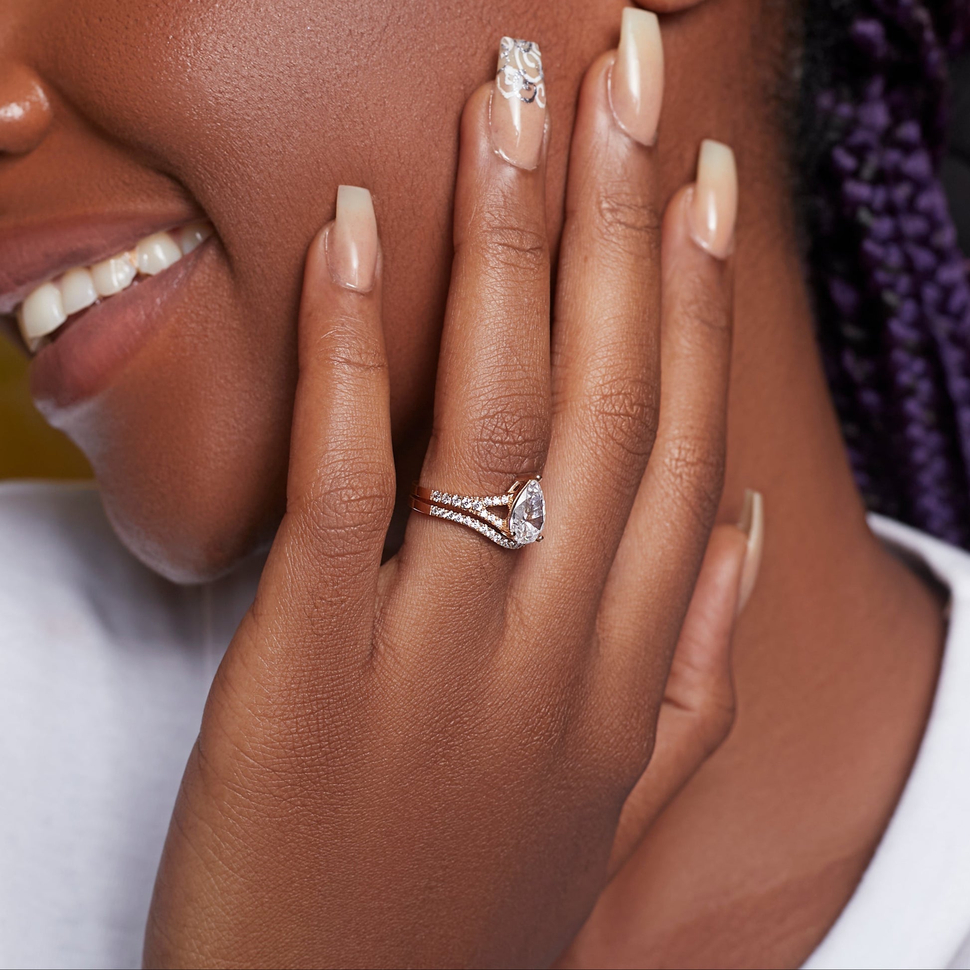 Close-up of a woman's hand with two diamond rings on a blurred background