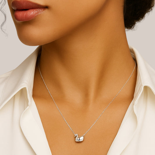 Silver necklace with a pendant worn by a model against a neutral background