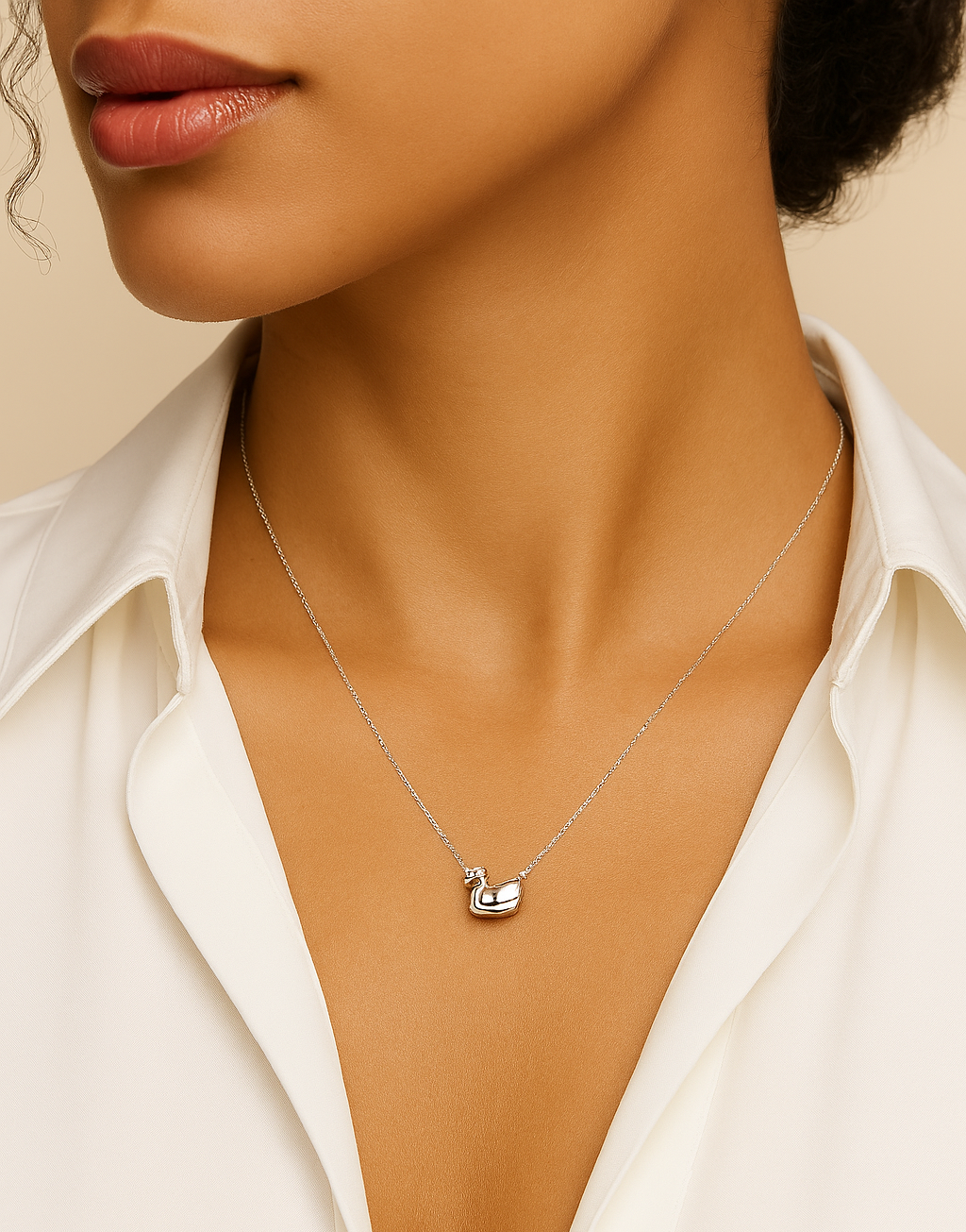 Necklace with a small pendant worn by a person against a neutral background
