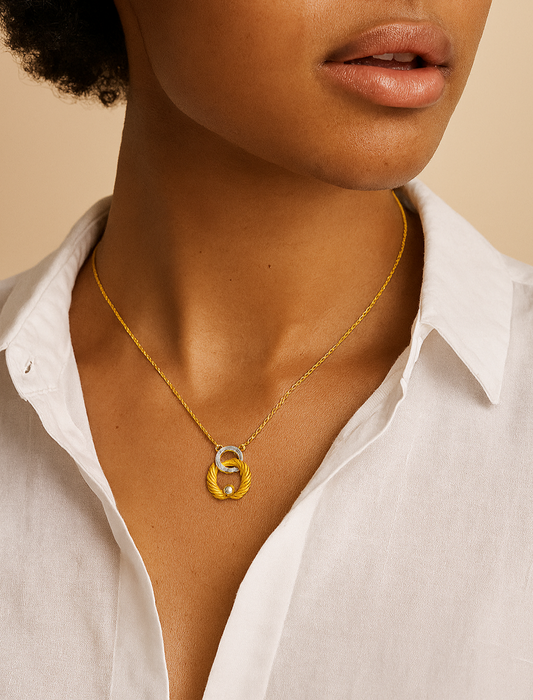 Close-up of a person wearing a gold necklace with a pendant against a beige background