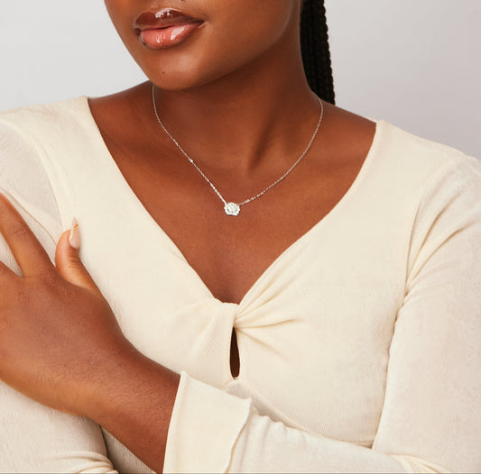 Woman wearing a white top with a plain background - VVS1 D Moissanite