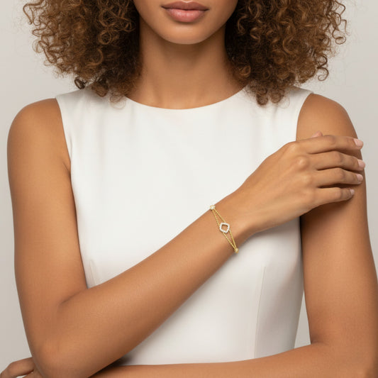 Woman wearing a gold bracelet on a plain background