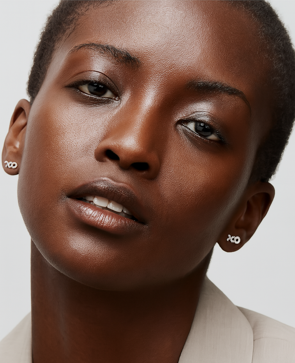 Close-up of a woman wearing earrings with a neutral background