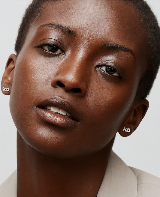Close-up of a woman wearing earrings with a neutral background