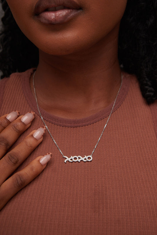 Necklace with a unique design worn by a person against a brown background