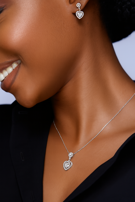 Close-up of a woman wearing a silver heart-shaped necklace and earrings.